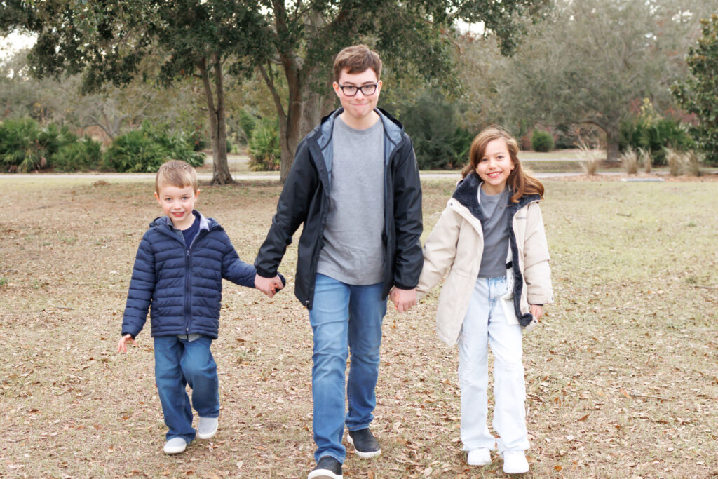 Family photo of three children holding hands