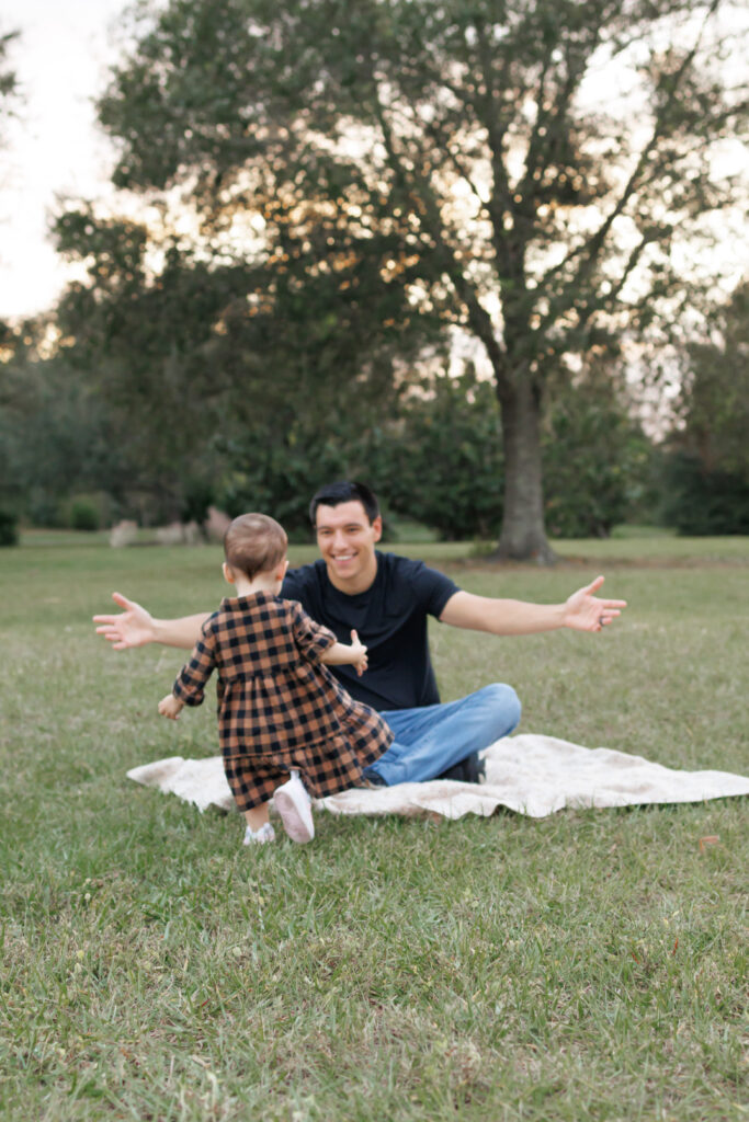 Lifestyle family photography of daughter running to hug dad